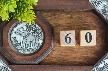 Number 60, Numbercube design with wooden board for background.