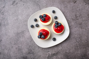 Mini cheesecakes with cherry and blueberry topping, sweet summer treat