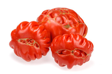 Organic tomatoes are a funny shape on a white background.