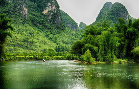 Tourist tour rafts boat on Li river, cruising between Gulin and Yangshou. This part of Guangxi province is very popular touristic destination because of unique mountains.