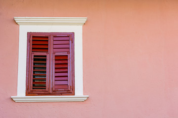 Fototapeta na wymiar Detail of olf wooden window with closed shutters.