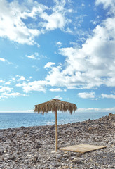 Fototapeta na wymiar Beach umbrella and a sunbed in Madeira Portugal