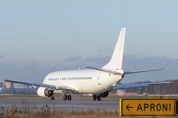 Aircraft taxiing to runway at the airport, in front of it is an inscription apron.