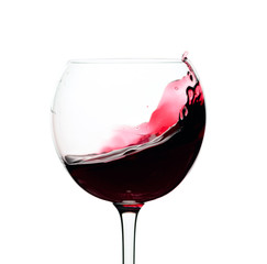 Splash of red wine in a glass isolated on  white.