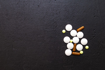 Fototapeta na wymiar tablets and pills on dark background. Space for text