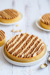 Delicious mini tarts with nuts and custard. Assortment of delicious and colorful dessert, salted caramel tart, lemon curd tart made by pastry chef. Striped Cake Decor.
