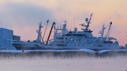 Early in the morning at dawn in the fog fishing ships are in the port of Petropavlovsk Kamchatsky