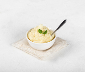 Mashed potatoes with greens on a light background in rustic style