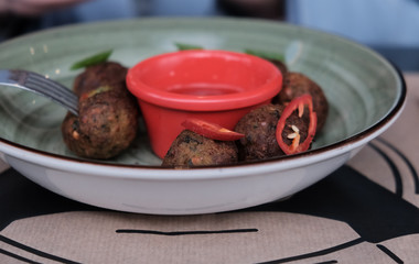 Falafel balls with parsley in wooden bowl with tahini sauce
