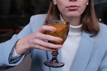 Woman drink hot orange tea in coat.