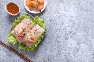 Spring rolls with shrimps and vegetables on grey. Close up. Asian cuisine. Horizontal orientation.