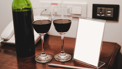 Two glasses of wine and wine bottle with phone on the wooden table