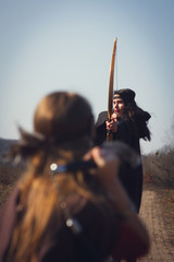 Warrior medieval woman with bow in battlefield