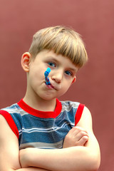 The child holds a toothbrush in his hand near his mouth.