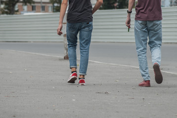 young men in jeans and sneakers walking down the street,