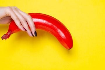 Banana painted red on a yellow background.