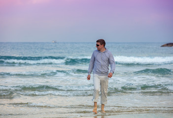 Fototapeta na wymiar Man walking on the beach . Person going on seaside