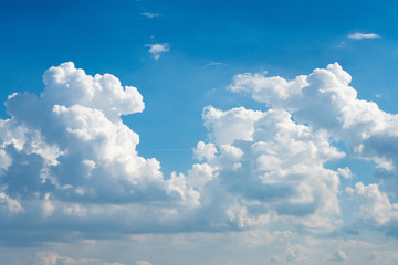 Naklejka na ściany i meble Glowing clouds on a background of blue sky. White fluffy luminous cloud