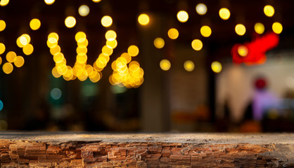 Blurred cafe bar, restaurant, club, blurred light golden bokeh background. With wooden tables in focus.