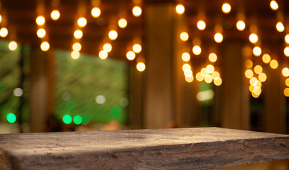 Blurred cafe bar, restaurant, club, blurred light golden bokeh background. With wooden tables in focus.