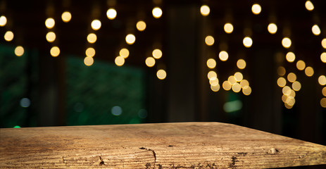 Blurred cafe bar, restaurant, club, blurred light golden bokeh background. With wooden tables in focus.