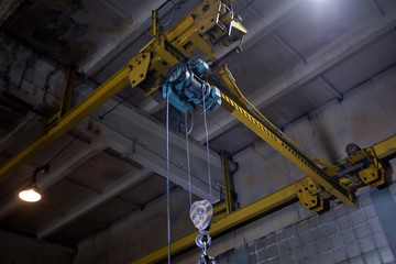 closeup of metallic lathe crane against factory industrial interior background