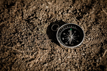 Fototapeta na wymiar compass on cracked soil. - travel and transportation concept.