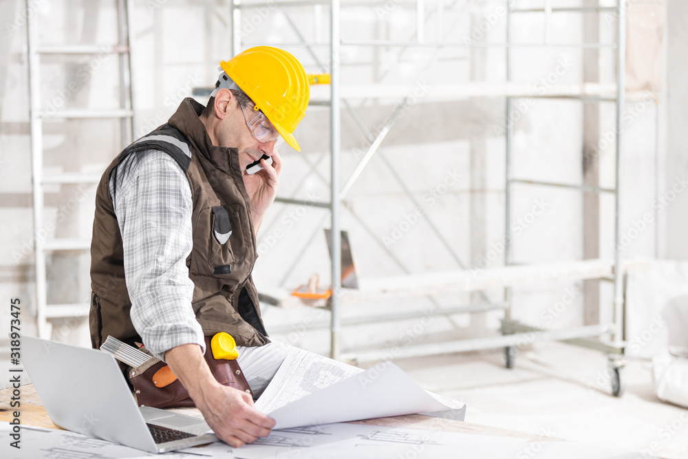 Wall mural Building contractor talking on a mobile phone