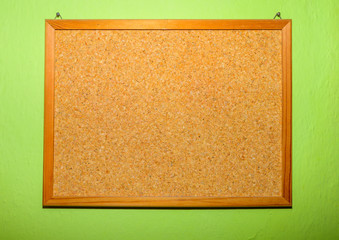 Fototapeta premium Blank Cork board with wooden frame on green background prepared for your reminder