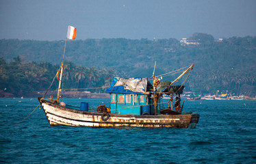 An old Indian fishing boat. The ship sails on the sea in search of fish.