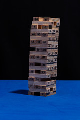 Juego de madera Torre de Babel en fondo negro y mesa azul con nmeros en cada ficha de madera y luz...