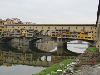 View of the Ponte Vecchio and its reflection on the Arno River in Florence, Italy 