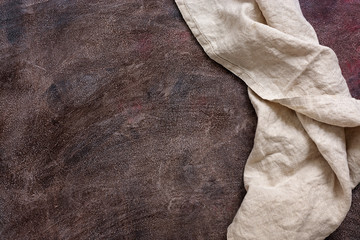 Napkin on brown painted rustic background. Top view, copy space.