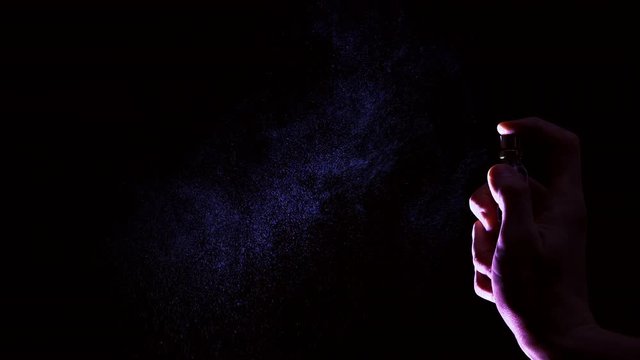 Perfume cloud on black background in slow motion