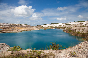 Turquoise beautiful lake formed after mining bauxite in subtropical forests on a clear Sunny day. Nature, ecology, and environmental protection.