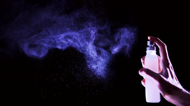 Perfume cloud on black background in slow motion