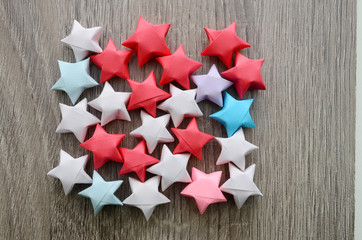 Folded origami stars over wooden background