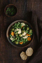Seasonal Italian minestrone soup with pasta, brussels sprouts, carrots and peas