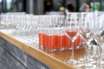 Glasses, a table with catering. Pours fruit compote.
