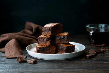 Homemade chocolate brownies on plate on dark background