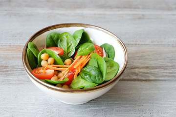 Spinach salad with tomatoes, carrots and chickpeas. Detox, healthy eating concept
