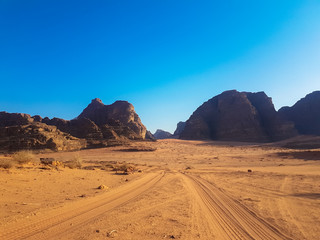 Fototapeta na wymiar Safari trip on pick-up trucks. Tire tracks on the sand. Nature park and reserve in Jordan. Scenic landscapes at the Wadi Rum desert. 