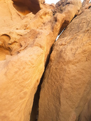 Huge sandstone rock with a crack in the middle of it. Yellow limestone cliff that has cracked apart. Sandstone wall background. 