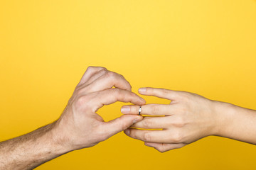 forever together. close up of man hand putting an engagement ring on a woman hand