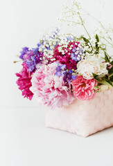 Bouquet of beautiful flowers with peonies and cornflowers in basket