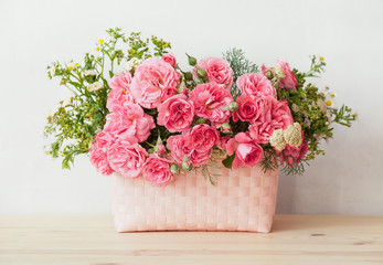 Basket with beautiful flowers on wooden tabl