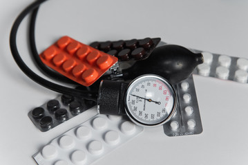 sphygmomanometer and pills  on white background