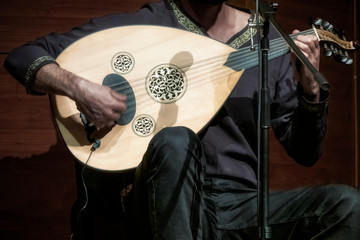 musician playing oud on stage