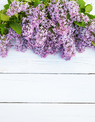 Bouquet of purple lilacs flowers on a light blue shabby wooden background. Vintage floral background with spring flowers. Copy space