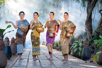 Water Songkran festival.Women group wearing Thai traditional costume play water in Songkran day...